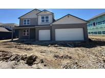 Two-story home boasts a two-car garage, gray brick facade and a covered porch entry, sitting on an unfinished lot at 201 Ames Dr, Whiteland, IN 46184