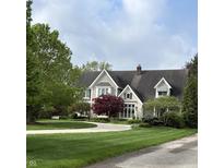 Charming home featuring classic architectural details, a circular driveway, and lush landscaping at 2090 Mulsanne Dr, Zionsville, IN 46077