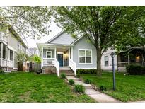 Charming home with a blue door, covered front porch and welcoming curb appeal on a bright, sunny day at 2237 N New Jersey St, Indianapolis, IN 46205