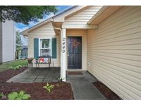 Inviting home exterior with a black front door, wreath, bench and well-maintained landscaping at 2449 Orchard Creek Dr, Columbus, IN 47201