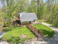 Inviting home featuring a large yard, multiple decks, and a charming walkway surrounded by lush greenery at 2985 Little Hurricane Rd, Martinsville, IN 46151