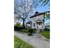 Charming two-story home with a covered front porch, manicured lawn, and mature shade tree at 301 N Main St, Franklin, IN 46131