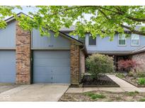 Charming home featuring a brick-and-blue exterior, attached garage and well-maintained landscaping at 3113 Sandpiper N Dr, Indianapolis, IN 46268