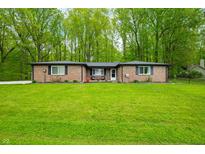 Charming brick ranch home with a lush green lawn and mature trees offering curb appeal at 4291 E Lakeview Dr, Martinsville, IN 46151