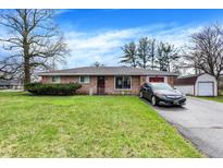 Charming brick home with a well-manicured lawn and attached garage, offering classic curb appeal at 5027 E 40Th St, Indianapolis, IN 46226