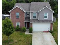Charming two-story home featuring a brick facade, gray siding, attached garage, and a well-manicured lawn at 7303 Beal Ln, Indianapolis, IN 46217
