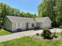 Charming single-story home with light gray siding and mature trees in a peaceful setting at 8310 Goat Hollow Rd, Martinsville, IN 46151