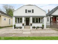 Charming home with a white brick facade, manicured landscaping, and welcoming front porch at 940 E Pleasant Run Parkway North Dr, Indianapolis, IN 46203