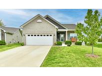 Charming brick home featuring a two-car garage, a manicured lawn, and a cozy front porch at 998 Cass Dr, Franklin, IN 46131