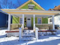 Charming front porch with snow-covered steps, offering a cozy entrance to this home at 104 N Chester Ave, Indianapolis, IN 46201