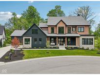 Stunning two-story home featuring a manicured lawn, stylish porch, and a mix of modern black and natural wood accents at 11064 Hamilton Run, Zionsville, IN 46077