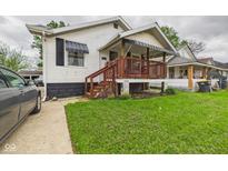Charming home featuring a covered front porch with wooden railings and a well-maintained lawn at 2314 Walnut St, Anderson, IN 46016