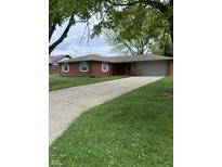 Charming brick ranch home with a well-maintained lawn and an attached two-car garage at 2935 Flintwood Dr, Columbus, IN 47203