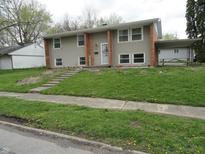 Split-level home with a brick facade, neutral siding, and a well-maintained front yard at 3426 Ireland Dr, Indianapolis, IN 46235