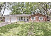 Charming single-story brick home features an attached two car garage and a well-manicured front lawn at 4050 Westover Dr, Indianapolis, IN 46268