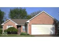 Charming brick home features an attached two-car garage and a well-maintained, verdant front yard at 4195 Knollwood Ct, Franklin, IN 46131