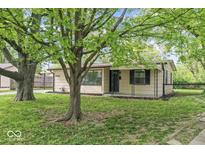 Charming single-story home featuring a well-maintained lawn and mature trees in a peaceful neighborhood at 4432 Brittany Rd, Indianapolis, IN 46222