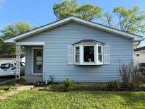 Charming one-story home featuring light blue siding, a bay window, and a well-maintained front lawn at 4820 Nowland Ave, Indianapolis, IN 46201