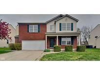 Charming two-story home featuring a red brick facade, attached garage, and manicured front yard at 6420 Greenspire Pl, Indianapolis, IN 46221