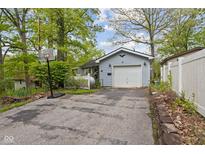 Cozy home featuring a one-car garage, basketball hoop and a private driveway surrounded by mature trees at 7 Lake Hart, Mooresville, IN 46158