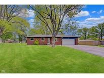 Charming brick home with a well-manicured lawn, attached garage, and inviting curb appeal at 8049 Burn Ct, Indianapolis, IN 46217