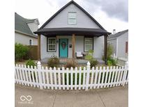 Charming home with a welcoming porch and a well-maintained, inviting white picket fence at 1035 Albany St, Indianapolis, IN 46203