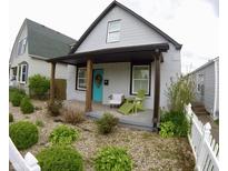 Inviting house with covered front porch, stylish chairs, and lush landscaping in a nicely designed space at 1035 Albany St, Indianapolis, IN 46203
