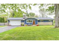 Charming single-story home with a blue exterior, a stone accent wall and mature landscaping at 10805 Charlemagne Dr, Indianapolis, IN 46259