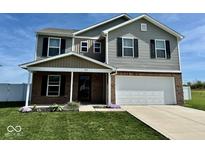 Two-story home with gray siding, brick accents, a manicured lawn, and an attached two-car garage at 1112 W Nature Pointe Ln, Muncie, IN 47304