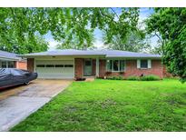 Charming brick ranch home featuring a well-manicured lawn and an attached two-car garage at 1225 N Graham Ave, Indianapolis, IN 46219