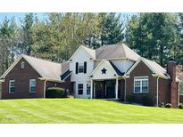 Charming two-story home with a well-manicured lawn and a brick and white exterior at 125 W Chalet Dr, Mooresville, IN 46158