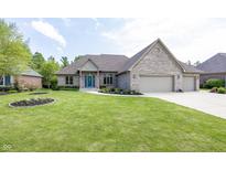 Beautifully landscaped brick home featuring an attached three car garage and a bright blue front door at 1297 Morningside Dr, Greenfield, IN 46140