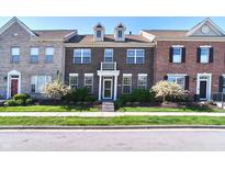 Charming brick townhome featuring a well-maintained lawn and inviting entrance at 13499 Molique Blvd, Fishers, IN 46037