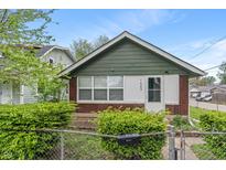 Charming single-story home with brick and green siding, fenced front yard, and bright natural light at 1602 Villa Ave, Indianapolis, IN 46203