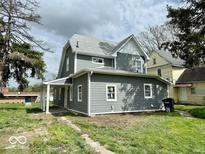 Charming two-story home with gray siding and white trim, surrounded by a green lawn at 1715 S Madison St, Muncie, IN 47302