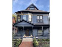Charming two-story blue home boasting a inviting front porch and lovely landscaped front yard, creating great curb appeal at 2161 N Pennsylvania N St, Indianapolis, IN 46202