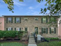 Charming brick townhouse with well-maintained landscaping and lovely green shutters at 3078 Armory Dr, Indianapolis, IN 46208