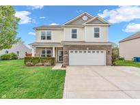Inviting two-story home with a brick-accented facade, manicured lawn, and attached two-car garage at 401 Shadetree Ln, Sheridan, IN 46069