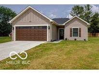 Charming one-story home featuring a well-manicured lawn, a brown garage door, and complementary siding at 403 Fox Ridge Ct, Shelbyville, IN 46176
