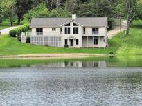 Charming lakefront home with large windows, inviting deck, and lush green lawn at 515 E Hoover Dr, Nineveh, IN 46164