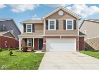 Inviting two-story home featuring brick and vinyl siding, a two-car garage, and a well-manicured lawn at 6540 Mccreery Ct, Indianapolis, IN 46221