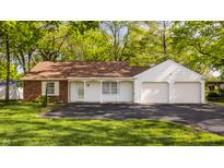 Charming ranch home featuring brick and white siding, an attached two-car garage and mature trees at 728 E Main St, Carmel, IN 46032