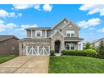 Charming two-story home featuring a stone and gray exterior with a well-manicured lawn at 769 Canberra Blvd, Westfield, IN 46074