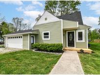 Charming home with green siding, black roof, manicured lawn, and inviting front porch at 8308 W Main St, Coatesville, IN 46121