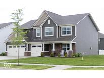 Charming two-story home featuring a three-car garage, brick accents, and a well-manicured lawn at 9176 Springbrook Dr, Pendleton, IN 46064