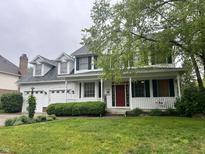 Charming two-story home with a red front door, manicured lawn, and a welcoming front porch at 10118 Leeward Blvd, Indianapolis, IN 46256