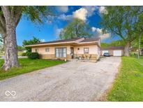 Charming single-story home with a long driveway and detached garage on a large lot with mature trees at 109 N Avon Ave, Avon, IN 46123
