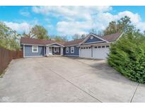 Charming blue home with a spacious driveway and a two-car garage, perfect for a growing Gathering at 10935 Cornell St, Carmel, IN 46280