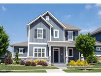 Charming two-story home featuring a covered porch, gray siding, stone accents, and professional landscaping at 1648 Rossmay Dr, Westfield, IN 46074