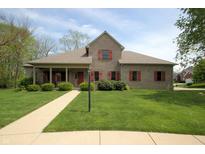 Charming brick home featuring a well-manicured lawn, red shutters, and a welcoming front porch at 17003 Whitebark Ct, Westfield, IN 46074
